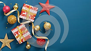 Christmas decorations on blue background with copy space. Flat lay gift boxes, pine tree branch, golden and red balls, star,