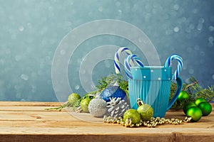 Christmas decorations with blue cup on wooden table over bokeh dreamy background