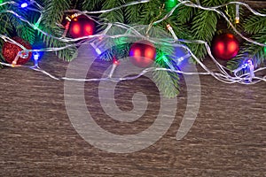 Christmas decorations with branches of fir tree and christmas lights, ball on wood on wooden background. copy space