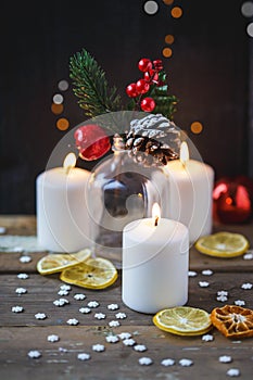 Christmas decorations, burning candles, candy ,citrus, spruce on a wooden background. New Year`s concept. Postcard