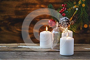 Christmas decorations, burning candles, spruce on a wooden background. New Year`s concept. Postcard
