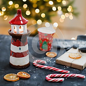 Christmas decorations, candles, candy cane, orange slices and Christmas tree with bokeh lights. Christmas, New Year 2021 concept