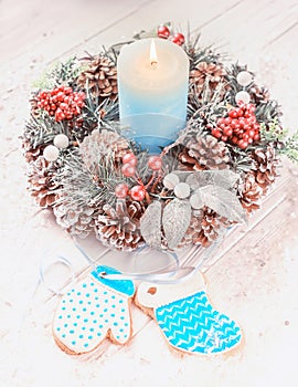 Christmas decorations for Christmas, wreaths and a candle and homemade gingerbread on a light background.