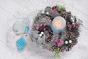 Christmas decorations for Christmas, wreaths and a candle and homemade gingerbread on a light background.