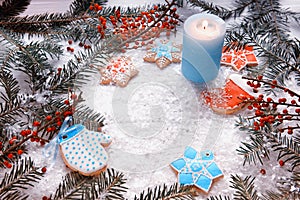 Christmas decorations for Christmas, wreaths and a candle and homemade gingerbread on a light background.