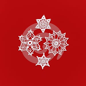 Christmas decorations. Composition from crocheted snowflakes isolated on red. Winter or Christmas background. square