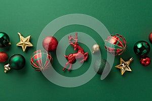 Christmas decorations concept. Top view photo of reindeer star ornaments gold green and red baubles on isolated green background