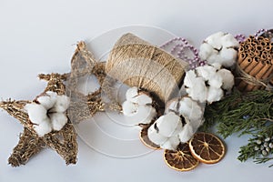 Christmas decorations eco cotton flowers, cinnamon,stars, spruce branches and jute rope hank over white background,holiday,xmas,ch