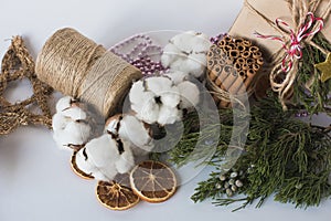 Christmas decorations eco cotton flowers, cinnamon,stars, spruce branches and jute rope hank over white background,holiday,xmas,ch