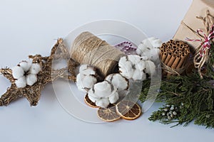Christmas decorations eco cotton flowers, cinnamon,stars, spruce branches and jute rope hank over white background,holiday,xmas,ch