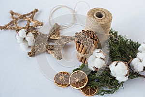Christmas decorations eco cotton flowers, cinnamon,stars, spruce branches and jute rope hank over white background,holiday,xmas,ch