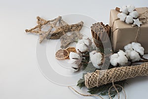 Christmas decorations eco cotton flowers, cinnamon,stars, spruce branches and jute rope hank over white background,holiday,xmas,ch