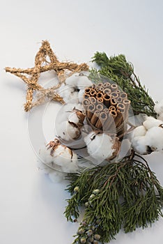 Christmas decorations eco cotton flowers, cinnamon,stars, spruce branches and jute rope hank over white background,holiday,xmas,ch