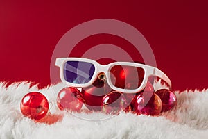 Christmas decorations, glasses for 3D cinema on a red background. New Year movies