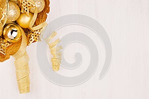 Christmas decorations, gold stars, balls and ribbons on soft white wooden background, copy space.