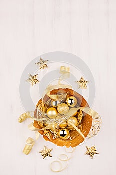 Christmas decorations, gold stars, balls and ribbons on soft white wooden background, copy space.