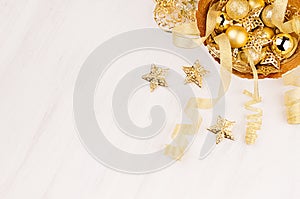 Christmas decorations, gold stars, balls and ribbons on soft white wooden background, copy space.