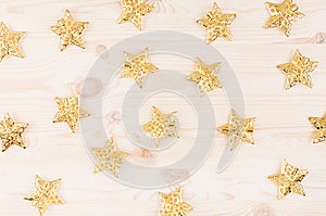 Christmas decorations, gold stars on soft beige wooden background.