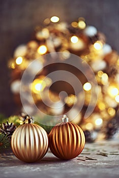 Christmas decorations with golden balls, fir tree branch and garland lights on a dark background