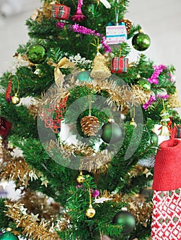 Christmas decorations green tree hanging, gold Gift box, green ball, brown Pine cones, socks, footwear, pink bell wrapped around