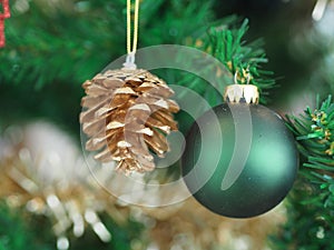 Christmas decorations green tree hanging, green ball, gold Pine cones, wrapped around it with a gold ribbon on white background