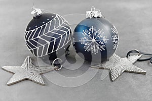 Christmas decorations on grey ground: two Christmas balls and stars