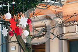 Christmas decorations hanging from a tree in a street food market, Christmas baubles and stars