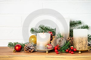 Christmas decorations indoor - Shelf with candles, fir tree branches and golden decor.