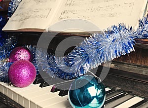 Christmas decorations lie on a piano.