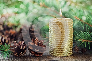 Christmas decorations with lighted candle, pine cones and fir branches on wooden background with magic bokeh effect, Christmas car photo