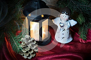 Christmas decorations with little toy angel, bright light glowing lantern