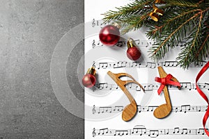 Christmas decorations, notes and music  on grey stone table, flat lay with space for text