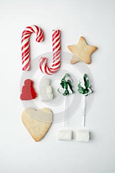 Christmas decorations and objects for mock up template design. Christmas candies, cookies, candy cane, decorative knitted hat.