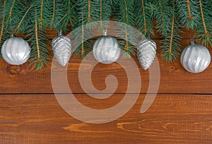 Christmas decorations and pine needles laid out flat on a dark wooden background with space for text