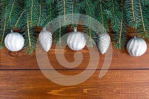 Christmas decorations and pine needles laid out flat on a dark wooden background with space for text