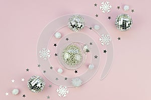 Christmas decorations on pink background. Mirror and silver glass Christmas tree balls diagonal chain line. Composition