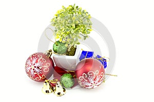 Christmas decorations with red ball,green ball,red ribbon,bell,small tree on white pot, and artificial flower