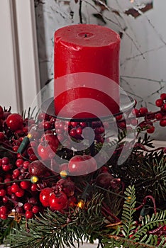 Christmas decorations with red candles and pine branch in white interior