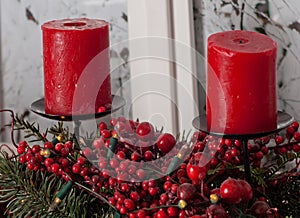 Christmas decorations with red candles and pine branch in white interior