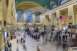 Christmas decorations red ribbon and wreath in the Grand Central Terminal and blurred people in Manhattan New York, USA