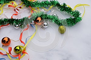 Christmas decorations are scattered on the table. Balls and garland of blue, golden and red colors on the table