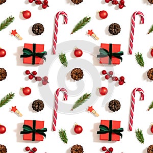 Christmas decorations seamless pattern on a white background. Gifts, fir branches, berries and lollipops. Winter concept. Top view