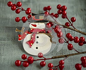 Christmas decorations snowman, red berries on wooden background