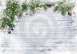 Christmas decorations on snowy wooden  background. border with fir branches, red berries and cones. Copy space