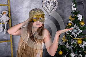 Christmas decorations in studio and woman in masquerade mask
