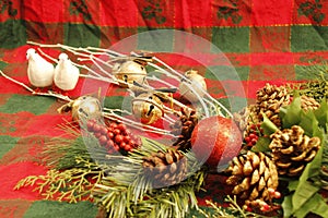 CHRISTMAS DECORATIONS, two white doves, gold jingle bells, pine cones, evergreen branches, red and green