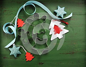 Christmas decorations on vintage green wood background, with cookie cutters.
