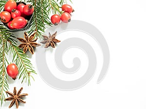 Christmas decorations on a white background, berries rose hips, stars, fir branches. copy space