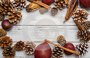 Christmas decorations on a white wood background with copy space. Pine cones, garland, berries and pine branches