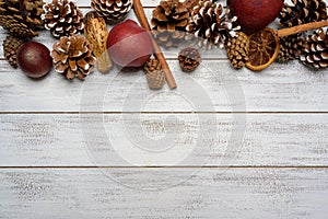 Christmas decorations on a white wood background with copy space. Pine cones, garland, berries and pine branches